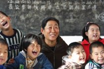 Сельская учительница и счастливые китайские ученики в классе — стоковое фото