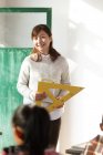 Сельская учительница улыбается и смотрит на учеников в классе — стоковое фото