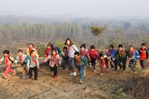 Молодая учительница и учащиеся сельских школ Китая играют на свежем воздухе — стоковое фото