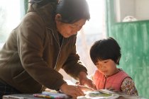 Сельская китайская учительница и ученица в классе — стоковое фото