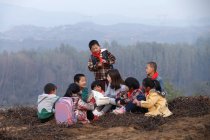 Profesor rural feliz y los alumnos en el aprendizaje al aire libre - foto de stock