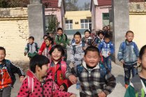 Feliz chino rural pupilos llegar a casa de la escuela - foto de stock