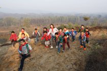Jeune enseignante et écolières rurales chinoises jouant en plein air — Photo de stock