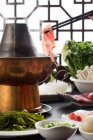 Close-up view of mutton hotpot and chopsticks with meat on table — Stock Photo