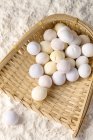 Vue de dessus des boules de riz gluantes sur le récipient en osier dans la farine — Photo de stock