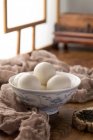 Vue rapprochée du bol avec des boules de riz gluantes sucrées sur une table en bois — Photo de stock
