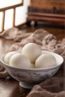 Vue rapprochée du bol avec de délicieuses boules de riz gluantes sur une table en bois — Photo de stock