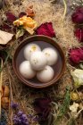 Top view of bowl with syrup and glutinous rice balls, dry flowers on table — Stock Photo