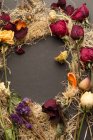Draufsicht auf schöne, verschieden arrangierte Trockenblumen auf dunkler Oberfläche — Stockfoto