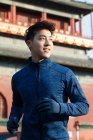 Schöner sportlicher junger asiatischer Mann läuft und schaut im Freien weg — Stockfoto