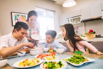 Щаслива Азіатська сім'я з двома дітьми, що обідають разом вдома — стокове фото