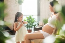 Selektiver Fokus des entzückenden Kindes mit Stethoskop beim Spielen mit schwangerer Mutter — Stockfoto