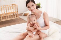 High angle view of happy young mother sitting with adorable infant child at home — Stock Photo