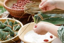 Plan recadré de femme préparant le plat de riz chinois traditionnel zongzi — Photo de stock