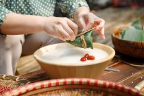 Vue partielle de femme cuisine traditionnelle chinoise plat zongzi — Photo de stock