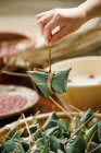 Частичный взгляд женщины, готовящей традиционное китайское блюдо zongzi — стоковое фото