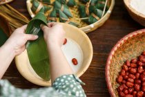 Abgeschnittene Aufnahme einer Frau, die traditionelles chinesisches Gericht zongzi kocht — Stockfoto