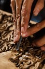 Vista parziale delle mani maschili durante l'incisione del legno in officina — Foto stock