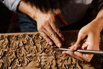 Teilansicht von Männerhänden bei der Holzgravur in der Werkstatt — Stockfoto