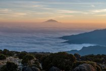 Дивовижний гірський пейзаж з мальовничими горами, вкритими хмарами під час сходу сонця — стокове фото