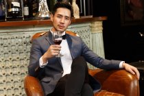 A young man with a red wine glass — Stock Photo