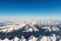 Aerial view of amazing rocky mountains, clouds and blue sky — Stock Photo