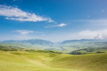 Дивовижний гірський пейзаж з зеленими пагорбами і блакитним небом в сонячний день — стокове фото