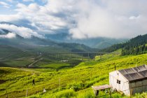 Paisagem da aldeia de montanha, colinas cobertas com vegetação verde e montanhas cênicas — Fotografia de Stock