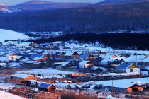Pueblo cubierto de nieve al amanecer, Mongolia Interior - foto de stock