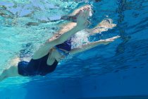 Mujer joven nadando en el agua - foto de stock
