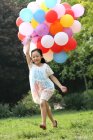 Fille tenant tas de ballons — Photo de stock