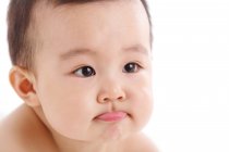 Close-up retrato de adorável asiático bebê menino olhando afastado no branco fundo — Fotografia de Stock