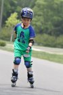 Niño patinaje en línea al aire libre - foto de stock