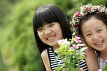 Portrait of two girls with flowers — Stock Photo