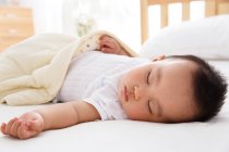Крупним планом вид на чарівну азіатську дитину, що спить у ліжечку — стокове фото