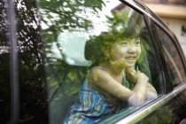 Glückliches kleines Mädchen sitzt im Auto — Stockfoto
