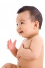Vista lateral de adorável feliz asiático bebê menino rindo e olhando para longe no fundo branco — Fotografia de Stock
