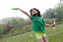 Girl making soap bubbles outdoors — Stock Photo