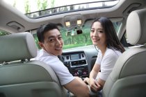 Les jeunes couples conduisent une voiture — Photo de stock