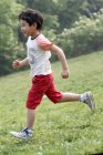 Junge spielt Fußball auf dem Feld — Stockfoto
