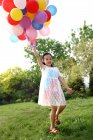 Menina segurando monte de balões — Fotografia de Stock