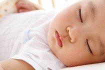 Close-up view of adorable asian baby sleeping in crib — Stock Photo