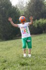 Garçon jouer au football sur le terrain — Photo de stock