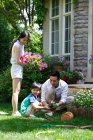 La felicità di una famiglia di tre persone nei fiori — Foto stock