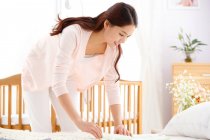 Young mother to organize baby clothes — Stock Photo
