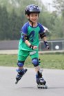 Niño patinaje en línea al aire libre - foto de stock