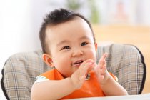 Cute happy asian baby boy sitting in chair — Stock Photo