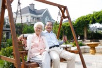 Счастливая пожилая пара сидит в кресле-качалке — стоковое фото