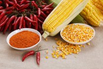 Close-up view of red hot chili peppers and corn — Stock Photo