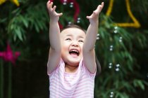 Excited the little girl is playing outdoors — Stock Photo